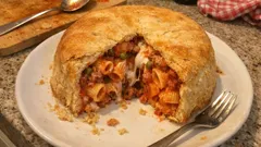 Timballo di rigatoni in crosta: salsiccia, piselli e mozzarella filante