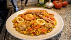 Paella mixta fatta in casa: riso allo zafferano con pollo e pesce, in una sola padella